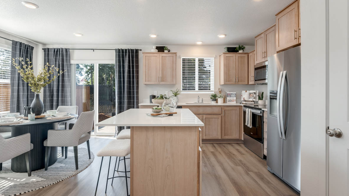 Ponderosa kitchen with island, stainless steel appliances, dining table, quartz countertops, a cabinets