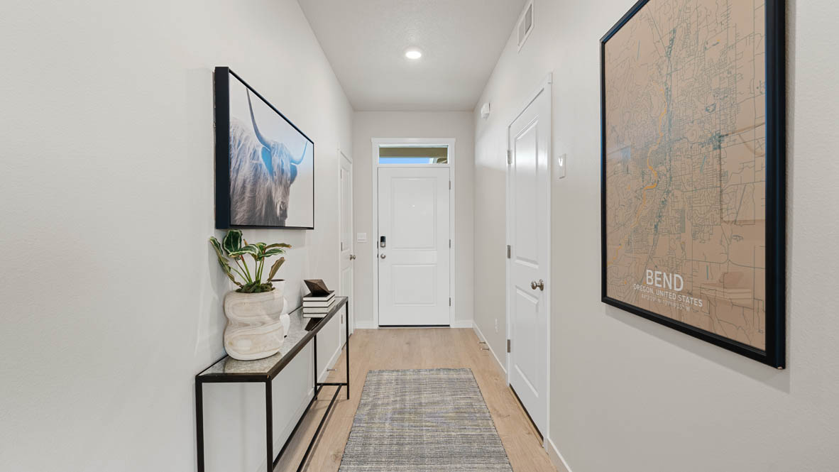 Stevens Ranch Entry with white walls, vignette, paintings, long rug, and white door