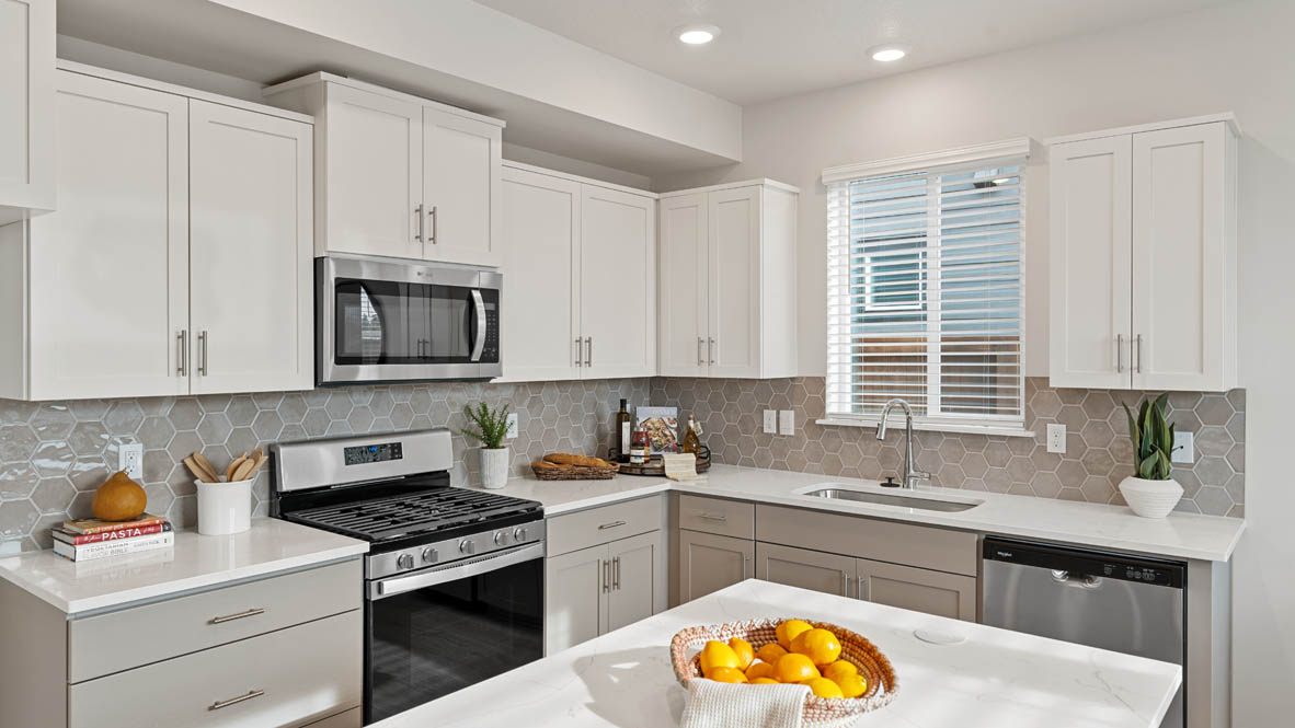 Stevens Ranch Kitchen with white quartz countertops, gray low cabinets, white upper cabinets, stainless steel appliances, window, and sink