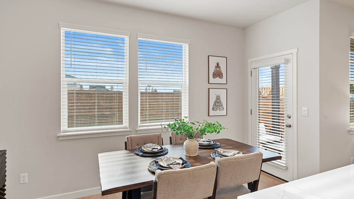 Stevens Ranch Dining room with table, two chairs, paintings, windows, and white walls