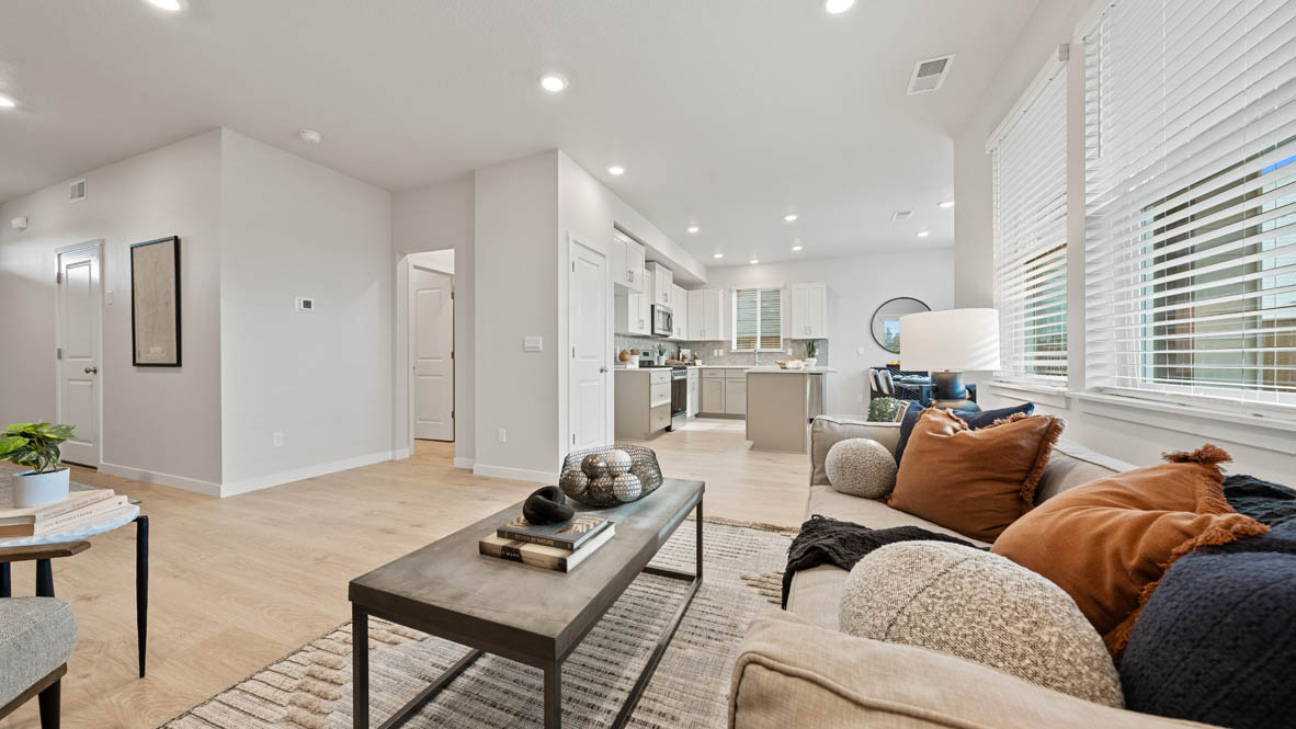 Stevens Ranch Stevens Ranch dining room with white couch, coffee table, paintings, windows, and laminate flooring