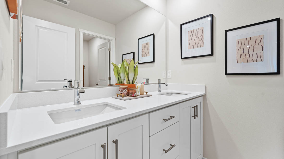 Stevens Ranch bathroom with white walls, quartz countertops, toilet, paintings, white cabinets, white tub