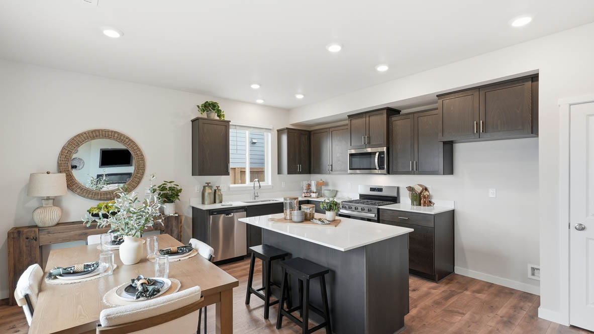 Stevens Ranch kitchen with stained shaker style cabinets, white quartz countertops, and stainless steel appliances