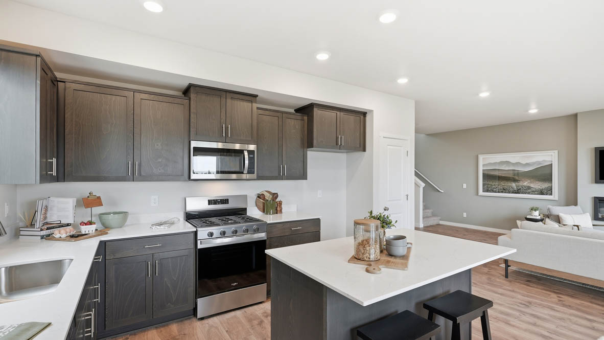 Stevens Ranch kitchen with stained shaker style cabinets, white quartz countertops, and stainless steel appliances