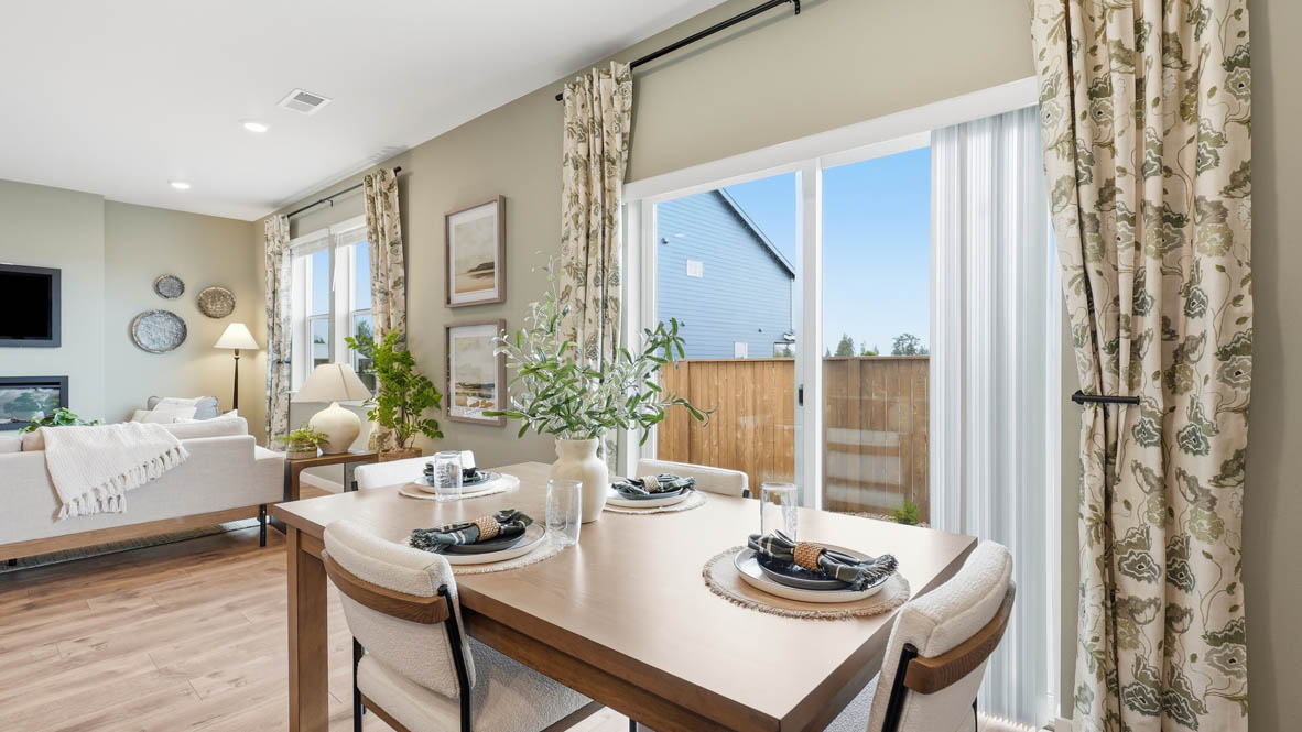 Stevens Ranch dining room with 4 place settings and sliding glass door to backyard