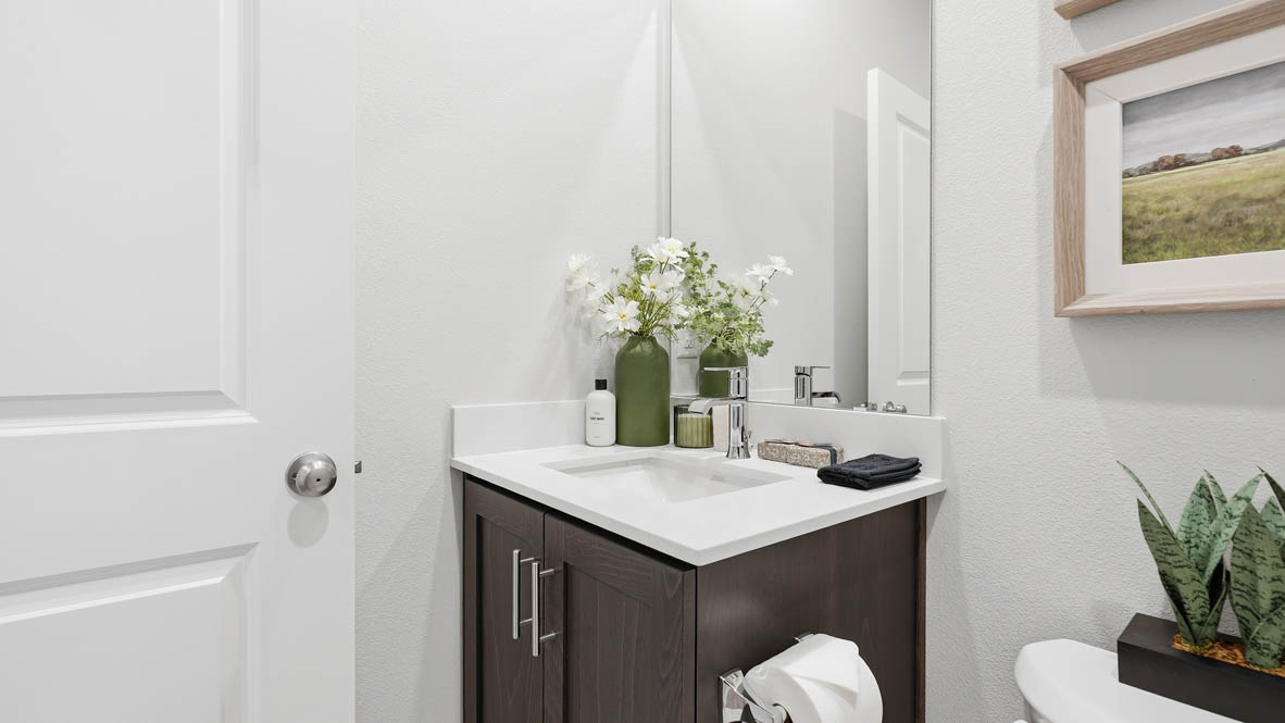 Stevens Ranch bathroom on the main floor with stained shaker style cabinet single sink vanity, toilet, and tub shower