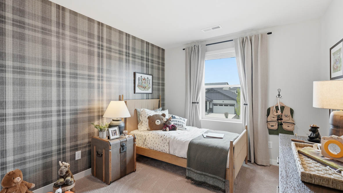 Stevens Ranch bedroom with twin bed and forest green theme with plaid accent wall