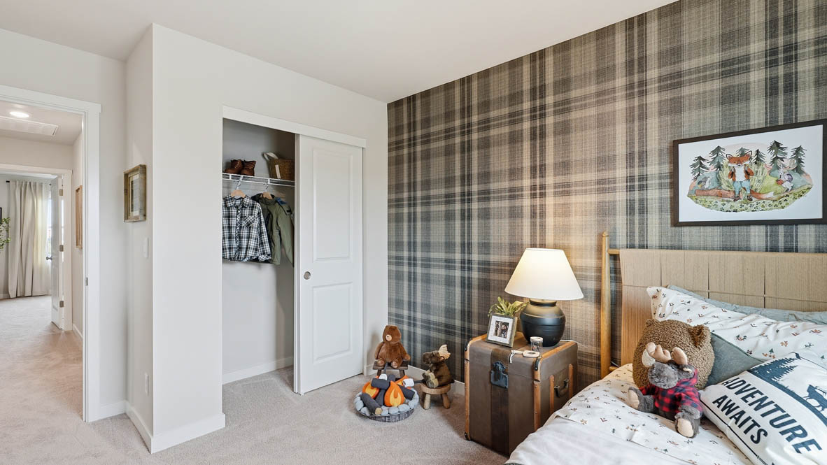 Stevens Ranch bedroom with twin bed and forest green theme with plaid accent wall