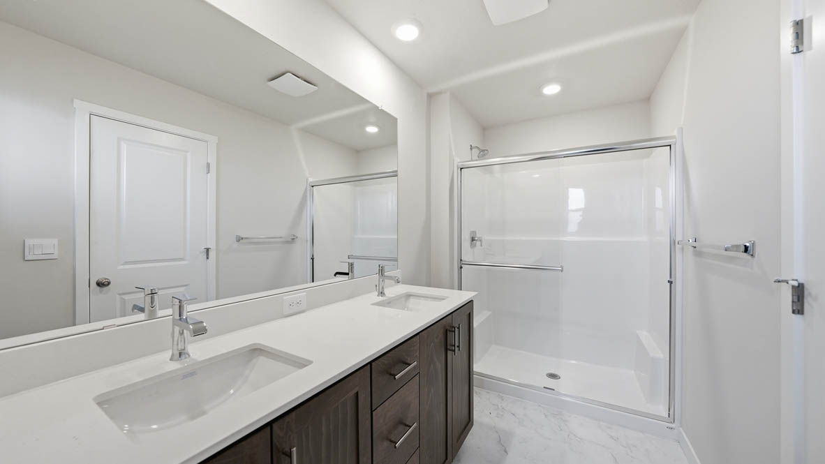 Stevens Ranch primary bathroom with vanity, mirror, walk in shower