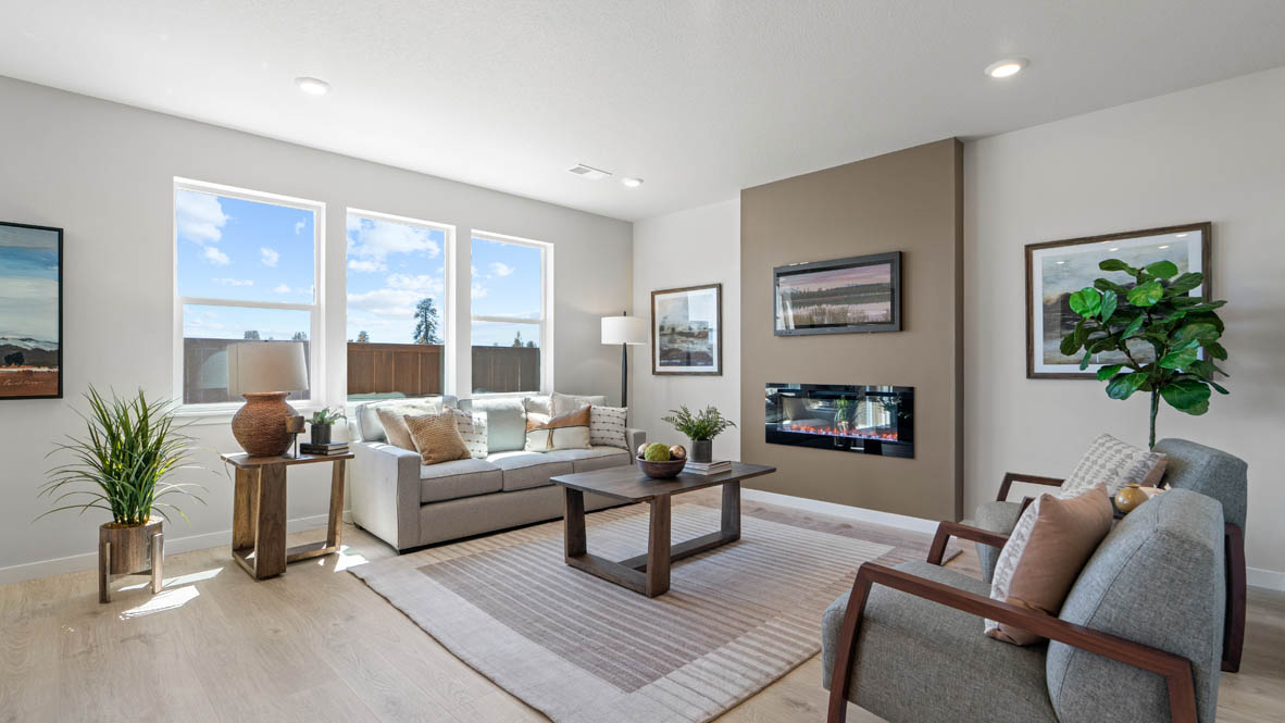 Stevens Ranch Great room with carpet, coffee table, couch, windows, plants, laminate flooring, and fireplace