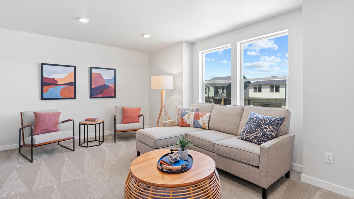 Stevens Ranch bonus room with sectional couch, coffee table, lamp, two chairs with a center piece, and two paintings