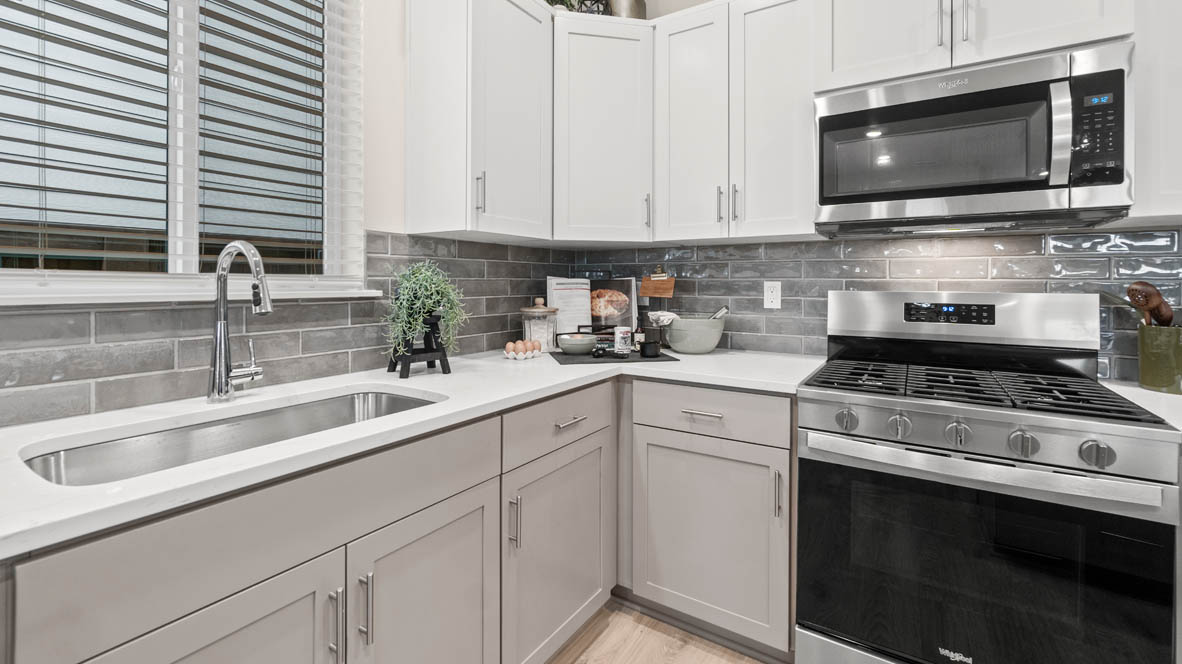 Stevens Ranch Kitchen with quartz countertops, gray cabinets, laminate flooring, stainless steel appliances, plant, windows