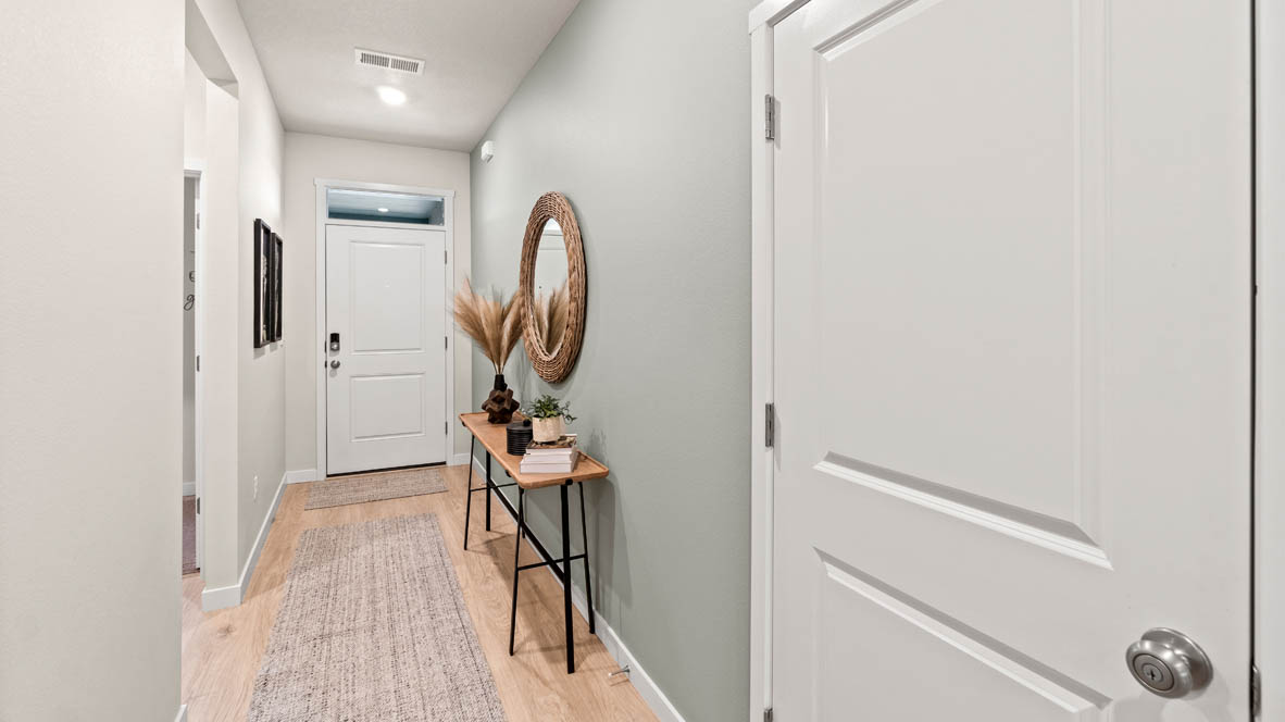 Stevens Ranch entry with mirror, entry table, laminate flooring, doors, and view entry door