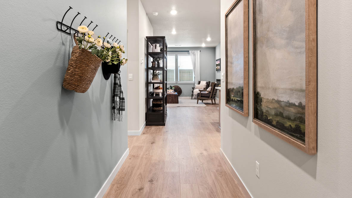Stevens Ranch hallway with paintings, laminate flooring, hat hooks, shelves