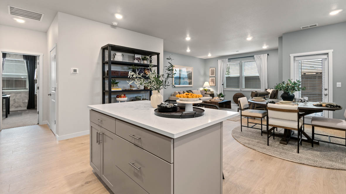 Stevens Ranch Kitchen with quartz countertops, gray cabinets, laminate flooring, stainless steel appliances, plant, and view of hallway