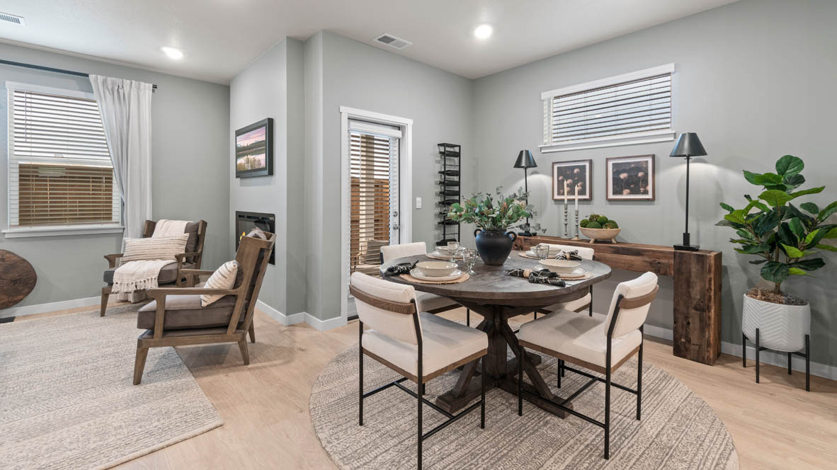 Stevens Ranch dining room with a table and four chairs, a plant on a stand, a lamp, a rug, decorative plant, tableware, door to outdoor patio, windows, side table, and view of great room