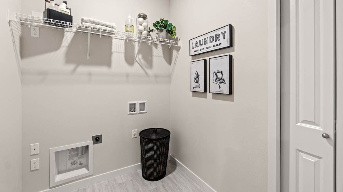 Stevens Ranch Laundry room with white wire shelving, paintings, a clothes basket, flooring