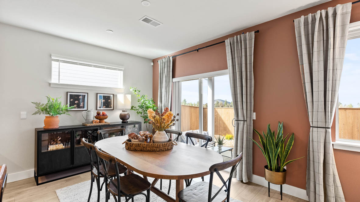 Stevens Ranch Diamond 3816 dining room with wood table, gray drapes, orange accent wall, black table, decorative plant