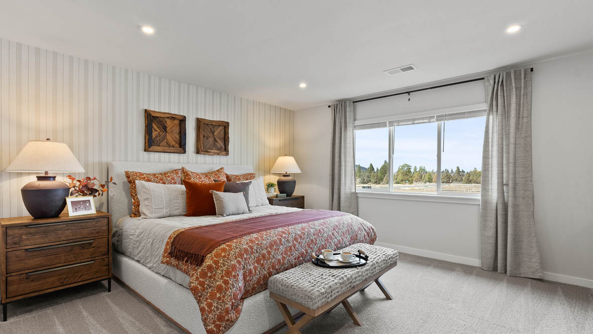 Stevens Ranch Diamond 3816 bedroom with carpet flooring and windows, bed with orange accent blanket and pillows, two paintings, two nightstands, two lamps