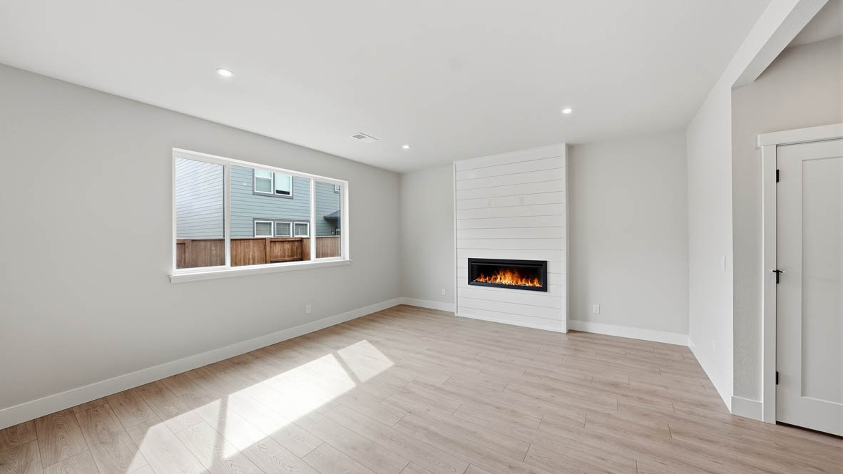 Stevens Ranch great room with laminate flooring, white walls, window, and electric fireplace