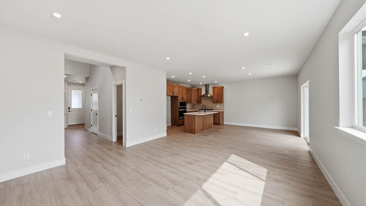 Stevens Ranch great room with laminate flooring, white walls, and window