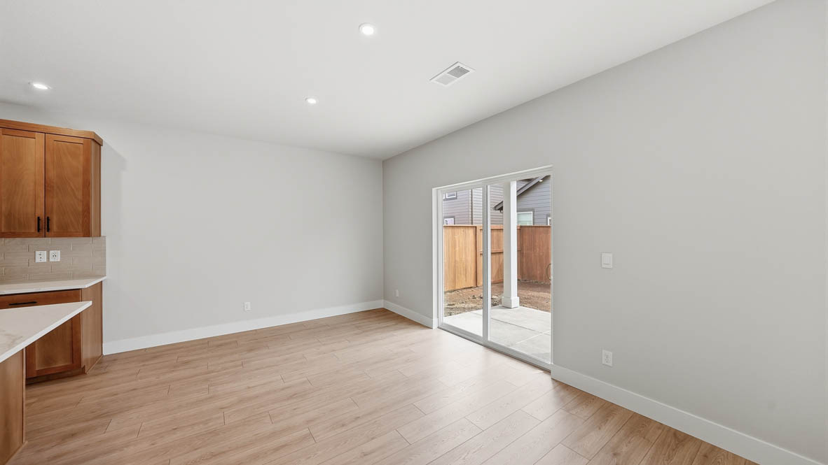 Stevens Ranch dining with laminate flooring, white walls, and glass sliding door