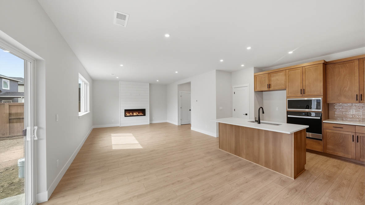Stevens Ranch dining with laminate flooring, glass sliding door, and kitchen with wood cabinets