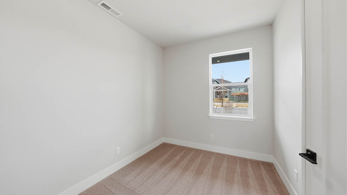 Stevens Ranch den with carpet, white walls, and window
