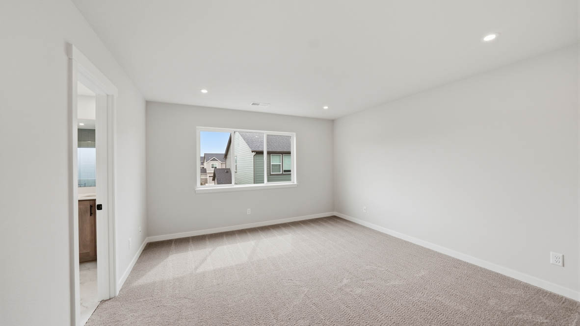 Stevens Ranch primary bedroom with carpet, white walls, and window