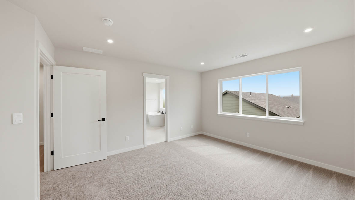 Stevens Ranch primary bedroom with carpet, white walls, and window