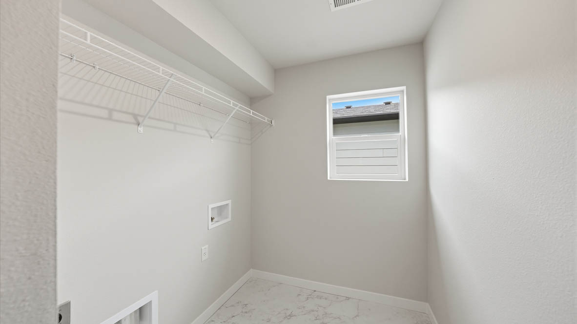 Stevens Ranch laundry room with white wire shelving, window, and white walls