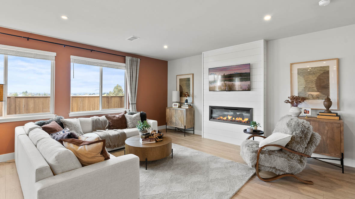 Stevens Ranch Diamond 3816 with hardwood flooring, fireplace, orange accent wall, white couches, coffee table,  two windows on the wall