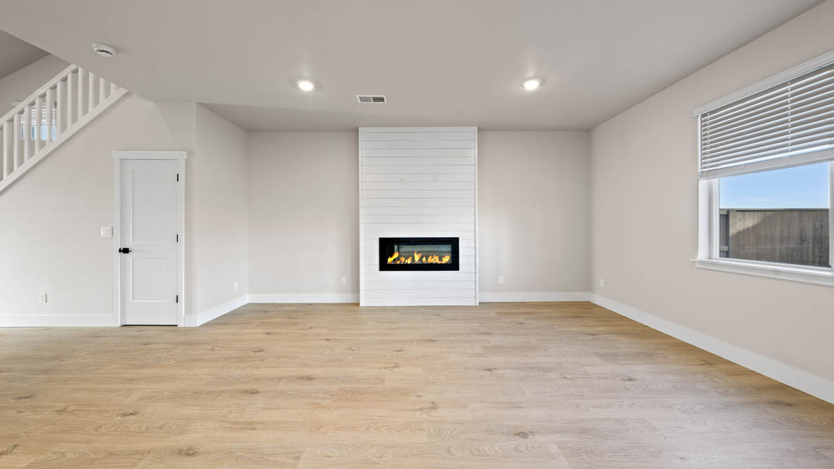 Stevens Ranch great room with windows, electric fireplace, windows, and flooring