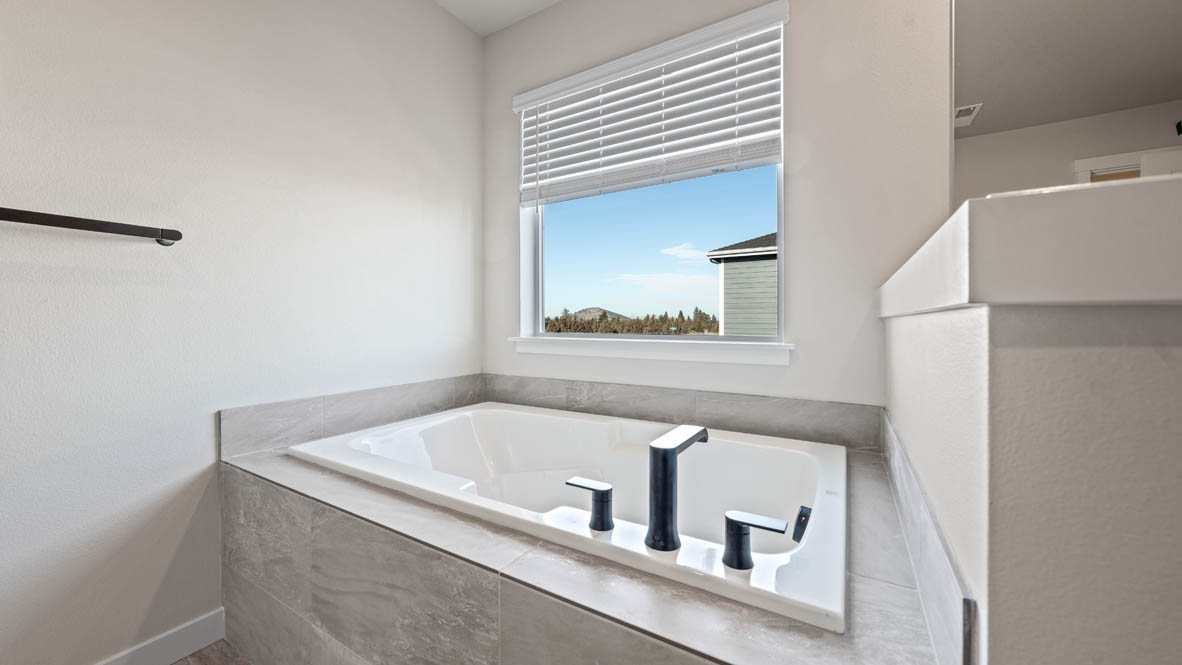 Stevens Ranch primary bathroom with bathtub and stained window