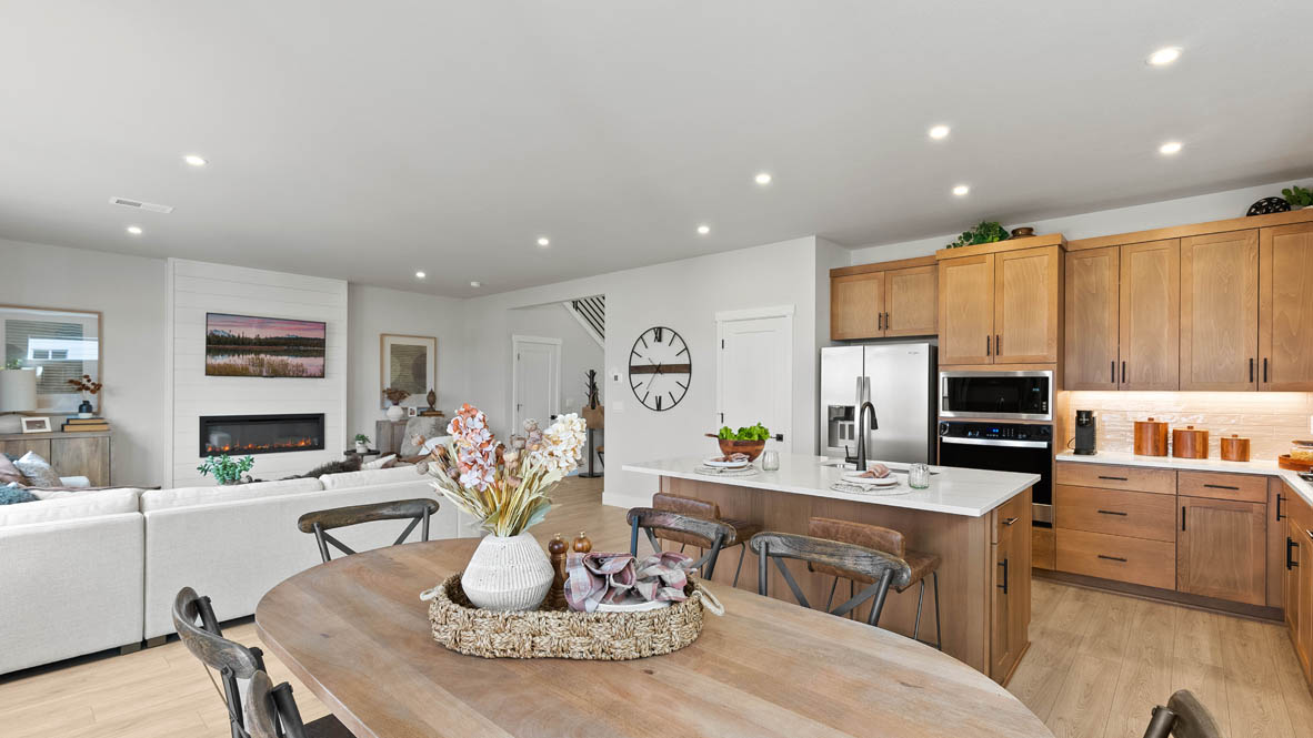 Stevens Ranch Diamond 3816 dining room with wood table, gray drapes, orange accent wall, black table, decorative plant