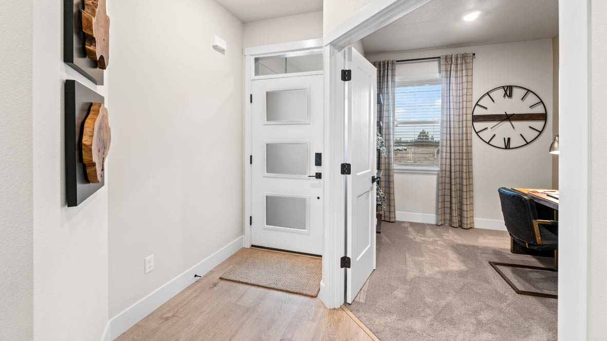 Stevens Ranch Entry with front carpeted den, laminate flooring, white walls, and window drapes