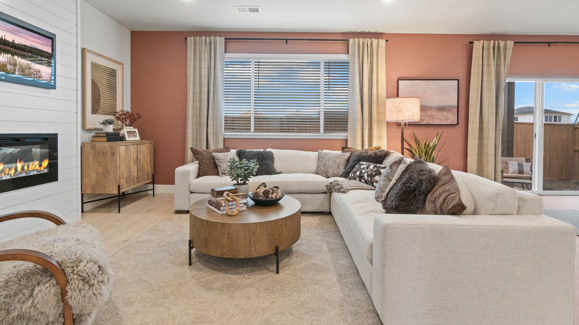 Stevens Ranch great room with L shaped sectional couch, carpeting, and center coffee table as well as window drapes