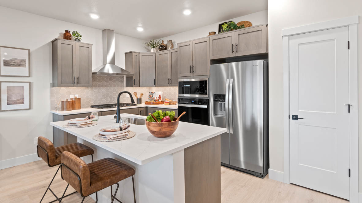Stevens Ranch Kitchen with island and white quartz countertops, stained wood shaker style cabinets, stainless steel appliances and full height geometric backsplash