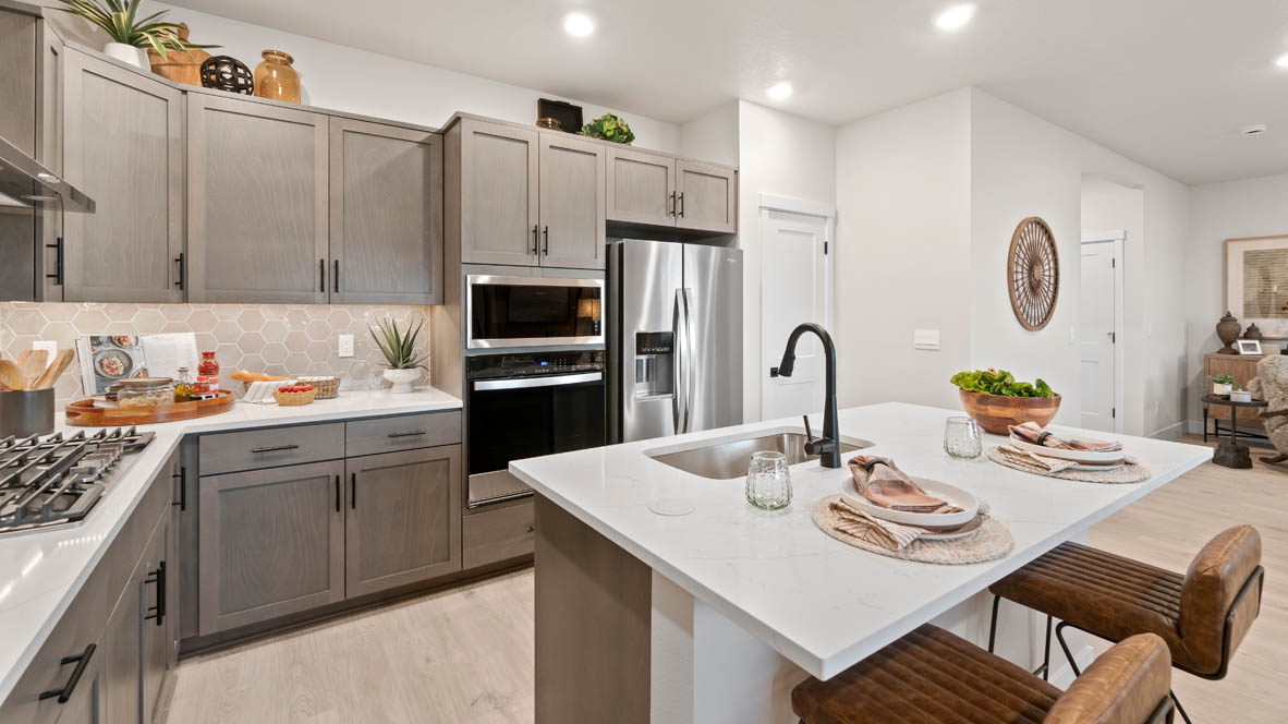 Stevens Ranch Kitchen with island and white quartz countertops, stained wood shaker style cabinets, stainless steel appliances and full height geometric backsplash