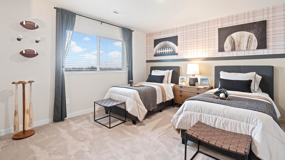 Stevens Ranch bedroom with two twin beds, sports theme, wall paper, and carpeting