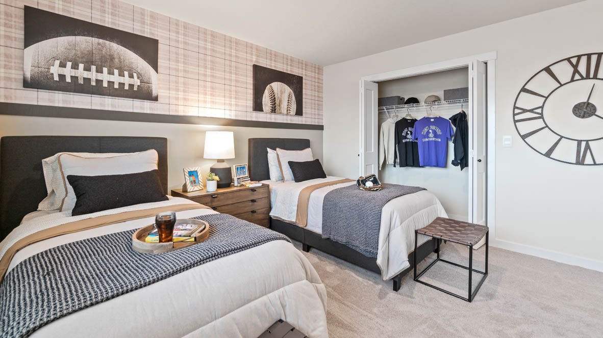 Stevens Ranch bedroom with two twin beds, sports theme, wall paper, and carpeting