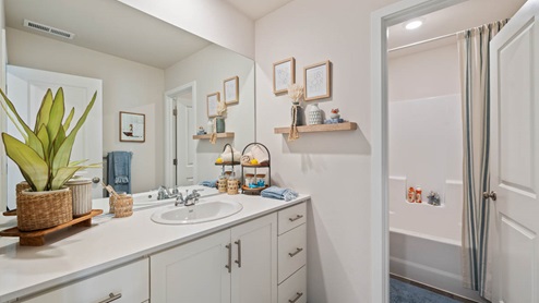 Monrovia Secondary Bathroom with single sink vanity and tub shower with white shaker style cabinets