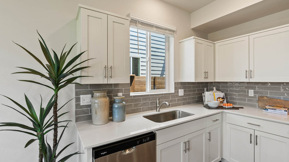 Monrovia Kitchen with quartz island, stainless steel appliances, cabinets, and window