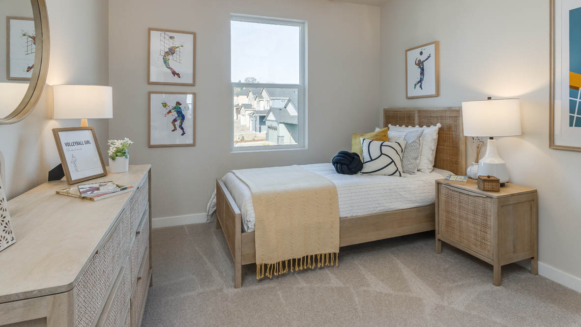 Monrovia bedroom with a bed and gray accent pillow, a nightstand and lamp, and window