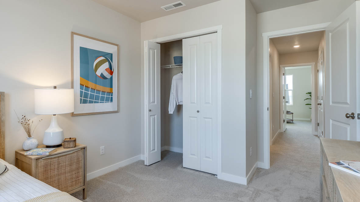 Monrovia bedroom with a bed and gray accent pillow, a nightstand and lamp, and closet