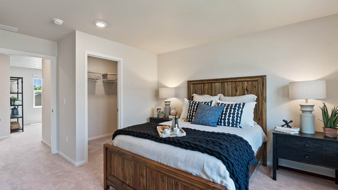 Monrovia Primary bedroom with nightstands with lamps, blue blanket, pillow, paintings, and closet