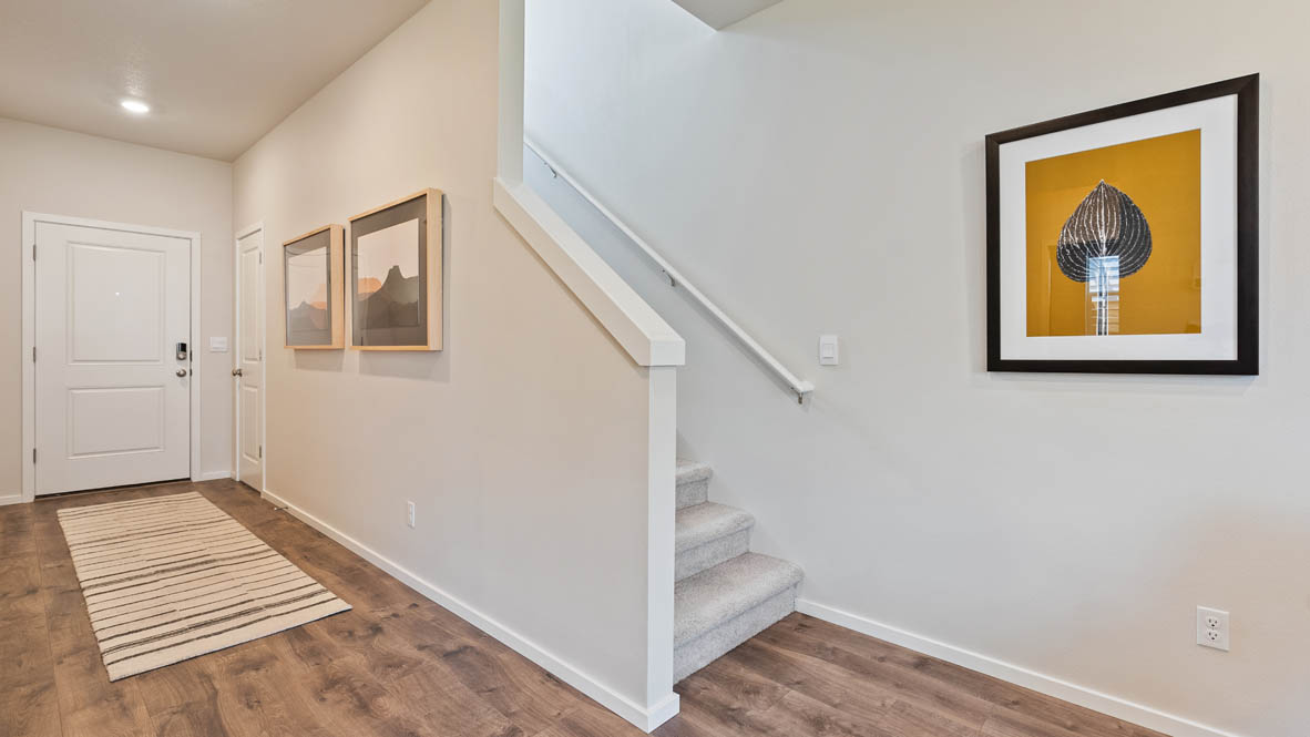 Monrovia Entry with carpet, painting, laminate flooring, and white walls