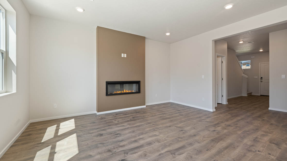 Monrovia great room with laminate flooring, windows, fireplace, and the hallway