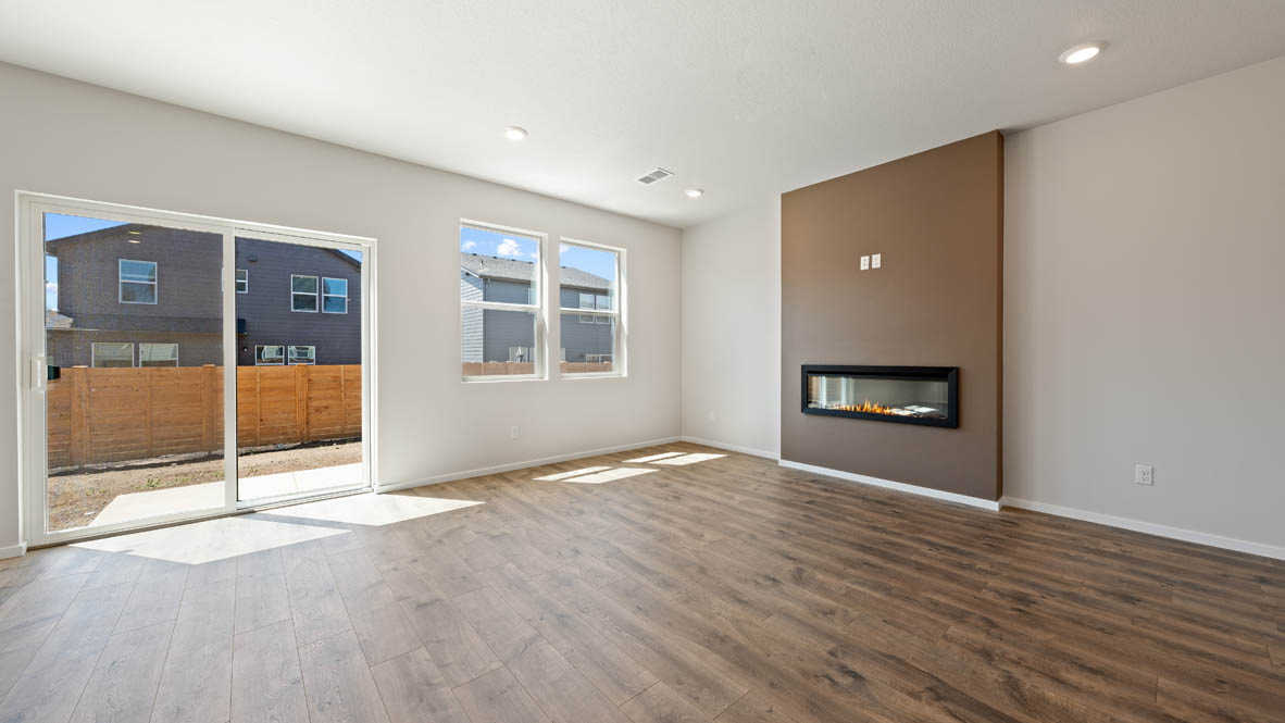 Monrovia great room with fireplace, laminate flooring, windows, and sliding glass door