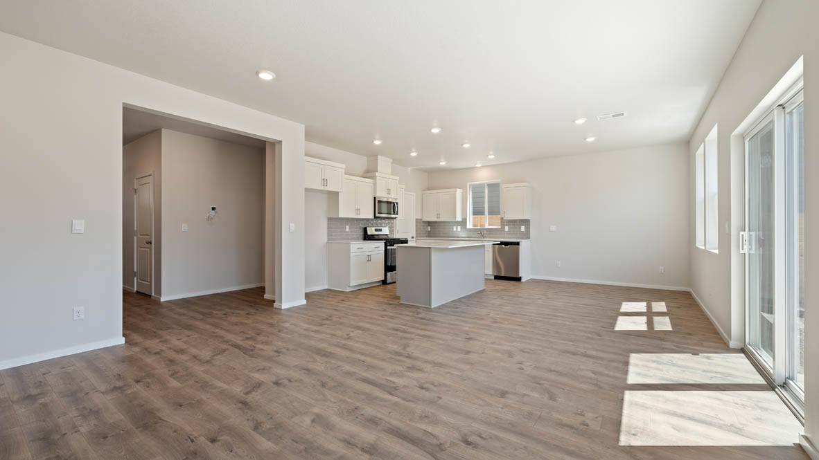 Monrovia kitchen and dining with laminate flooring, windows, sliding glass door, and kitchen in the background